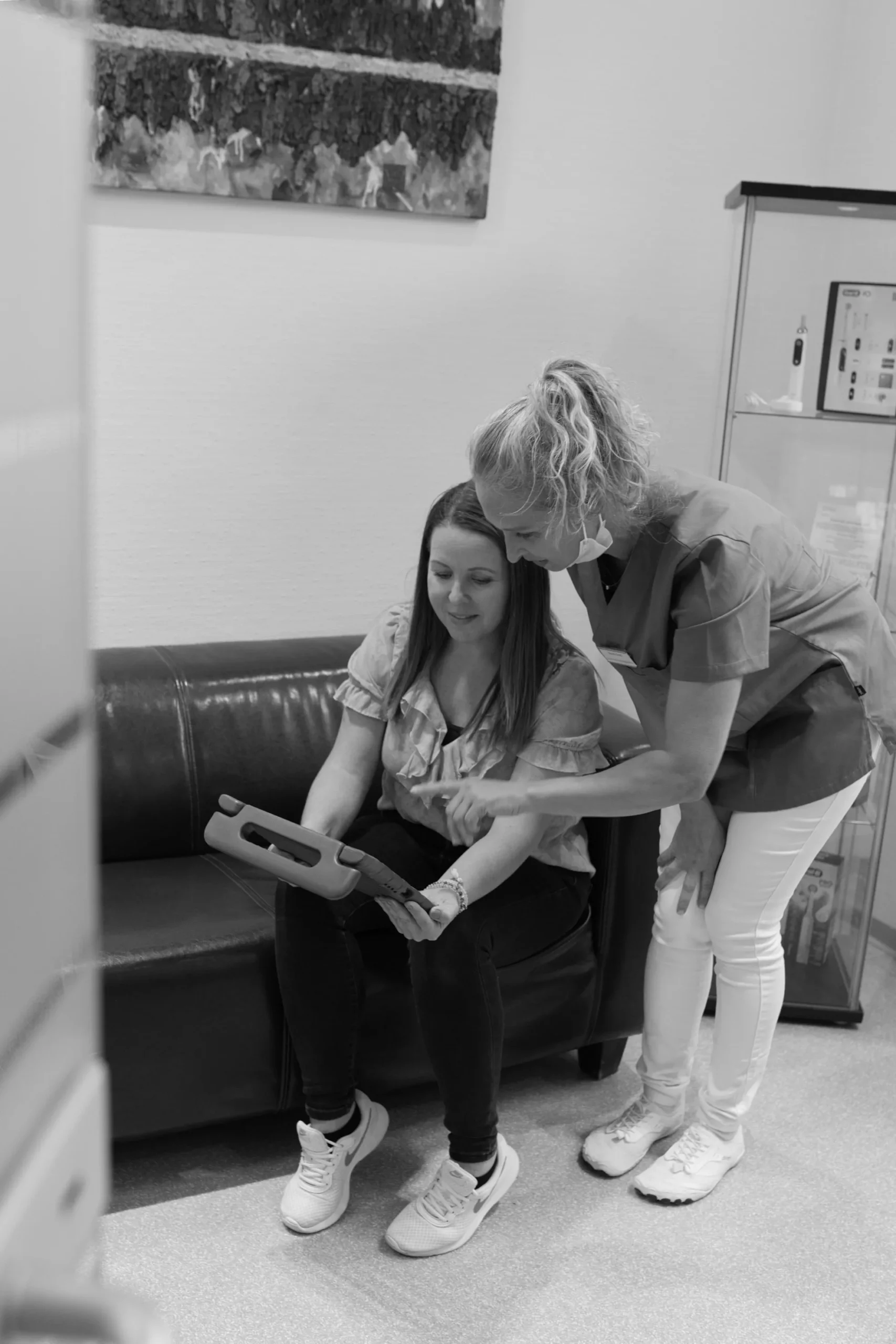 ZFA erklärt einer Patientin etwas am Tablet